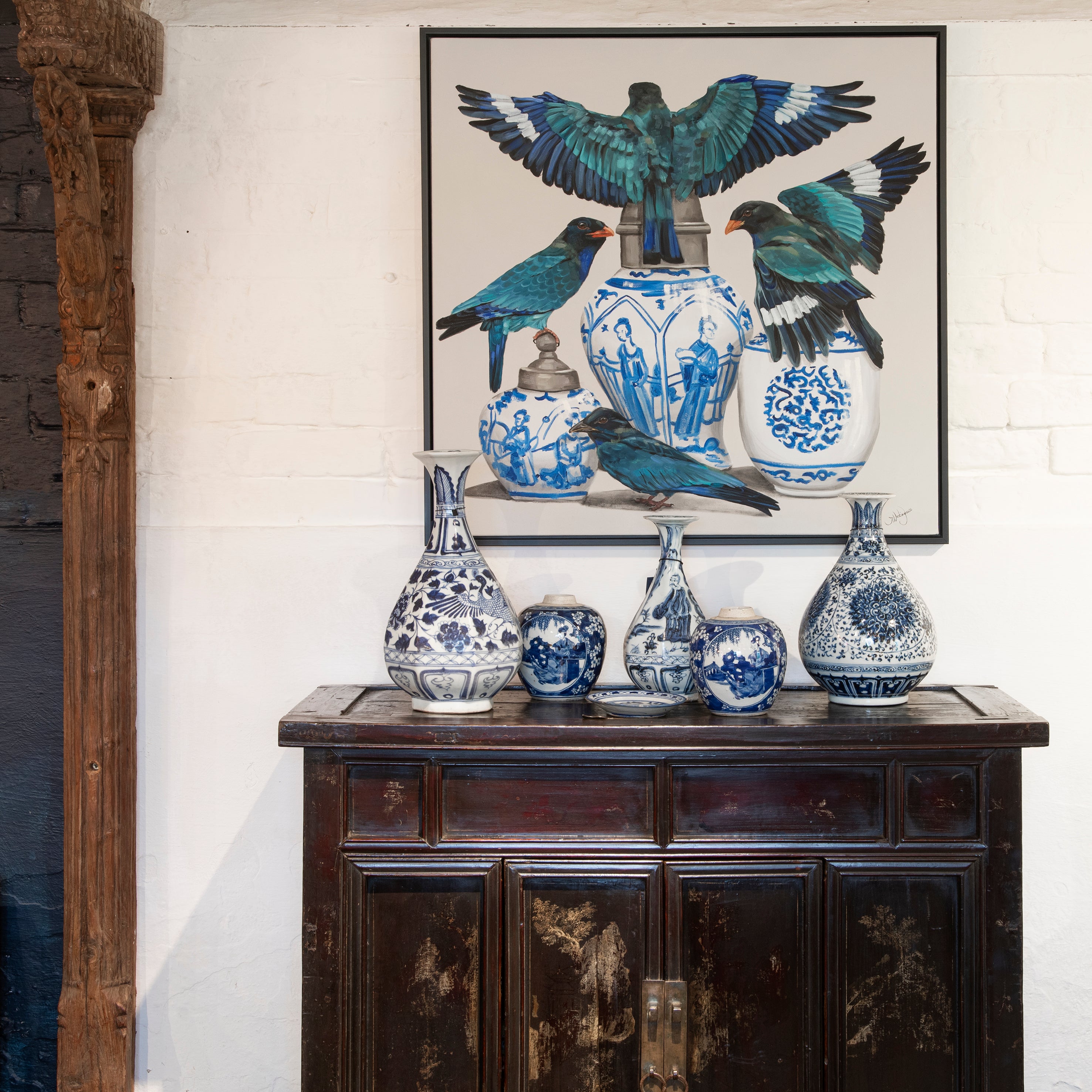 Blue and white porcelain vases of varying sizes on an antique sideboard