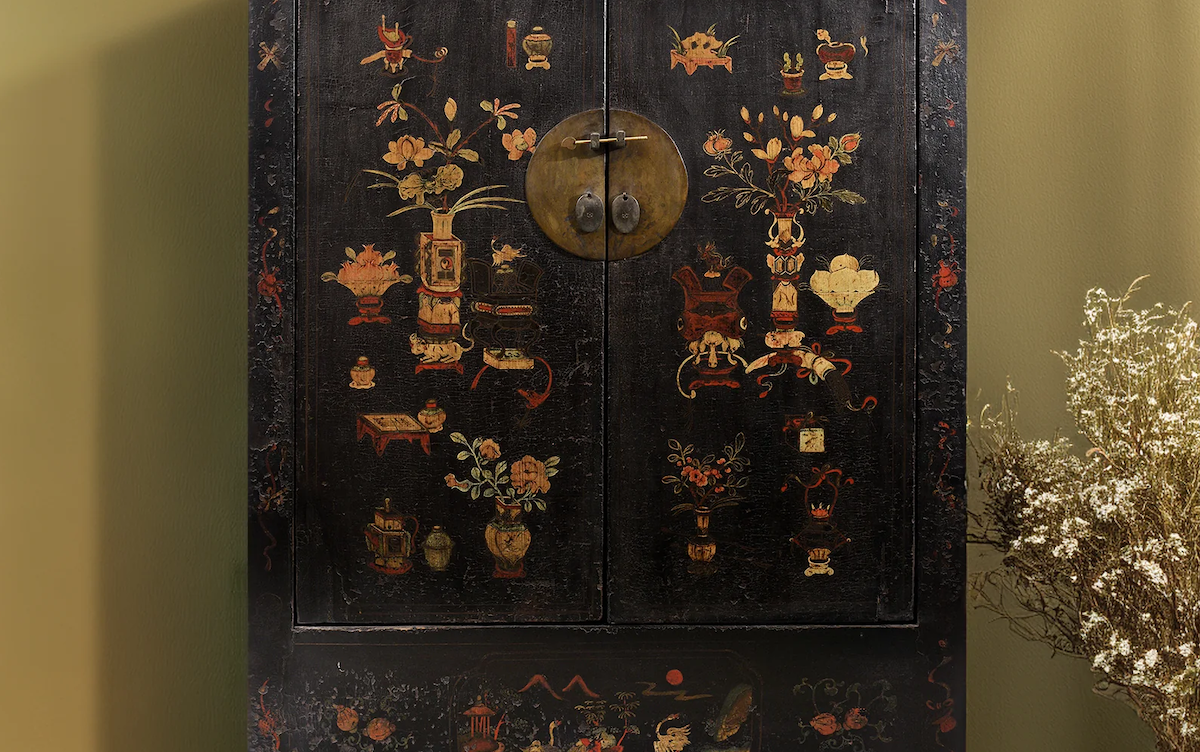 Black painted Chinese cabinet against a green wall