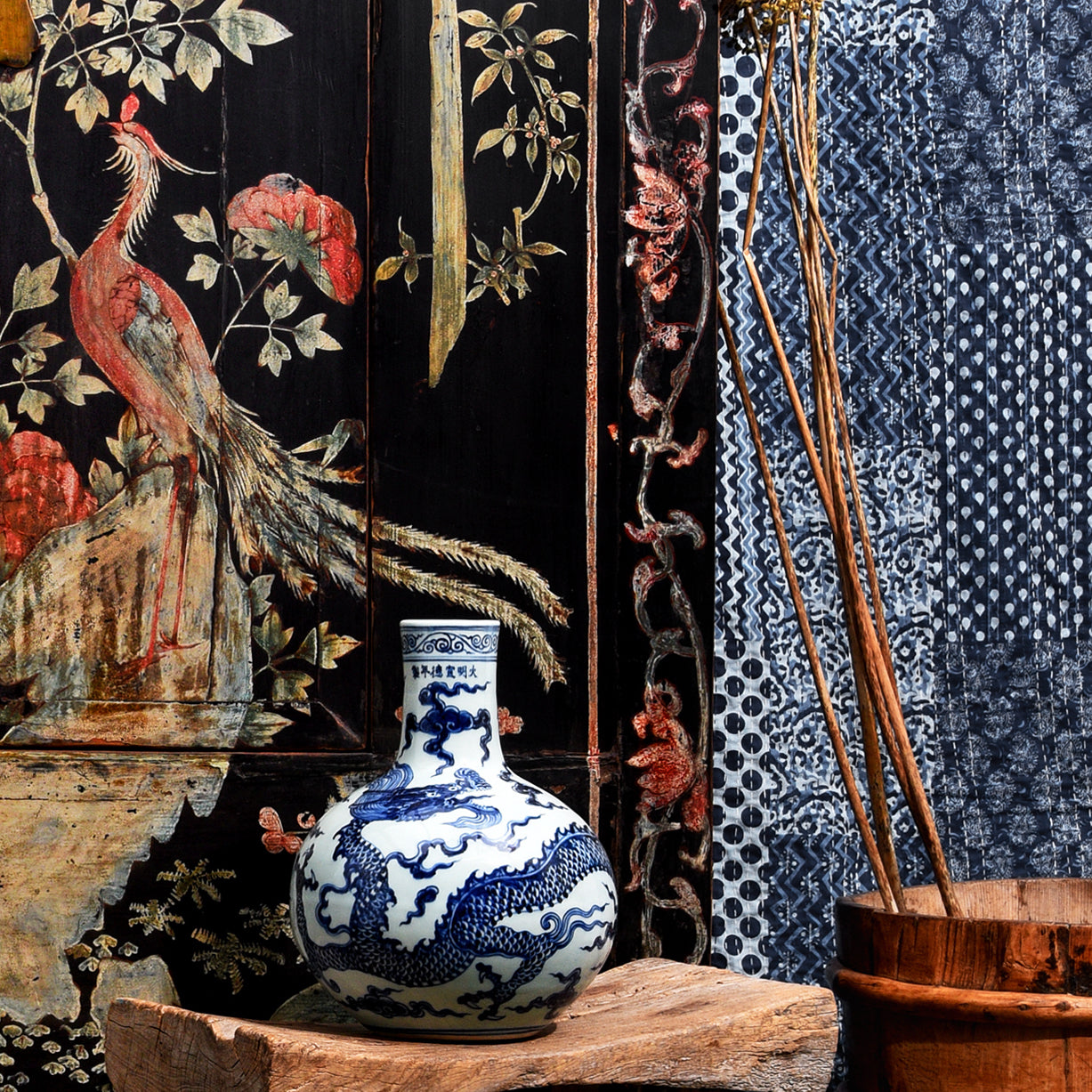 Blue and white Chinese porcelain vase next to a textile with a similar coloured pattern