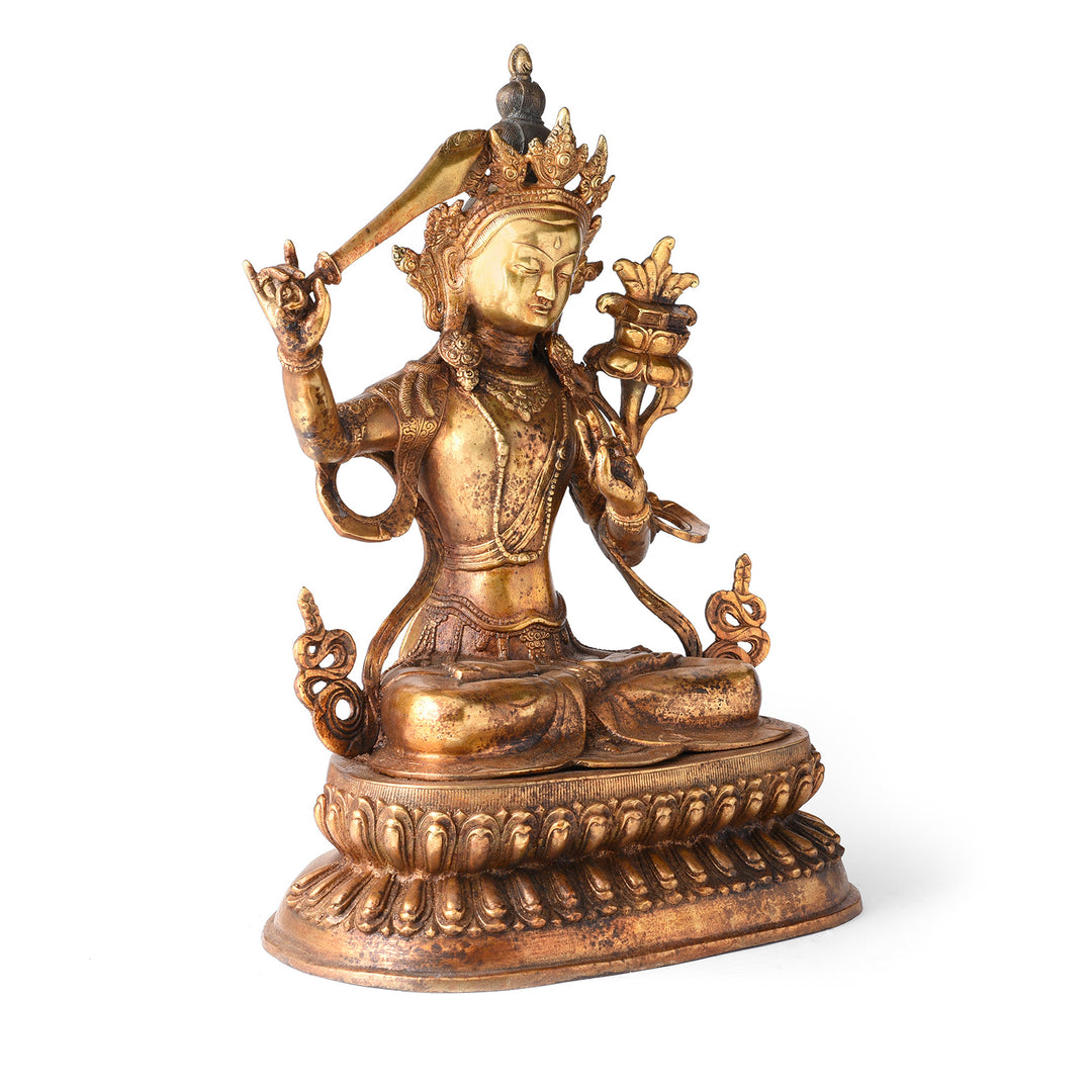 Angled View Of Gilded Brass Statue Of Tibetan Manjushri With his Sword Held High On a Lotus Throne| Indigo Antiques