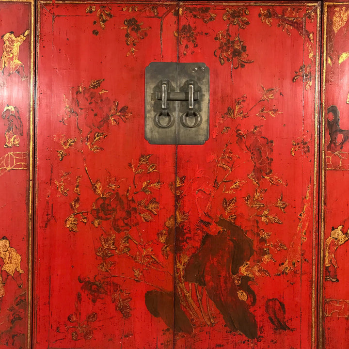 An old gilt red lacquer wedding cabinet from Shanxi province in China with scenes of rocks and flowers and children playing. 